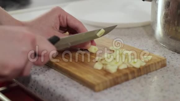 女人在木切板上切蒜视频的预览图