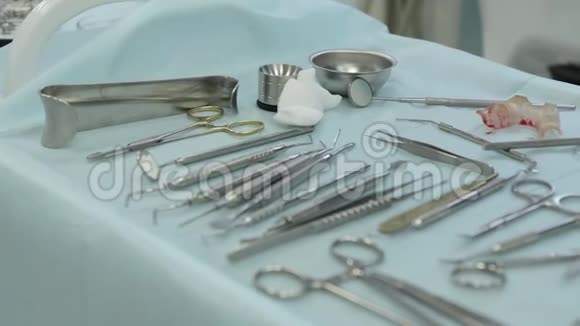 戴白橡胶手套的医生在牙科诊所的桌子上放置牙科工具视频的预览图