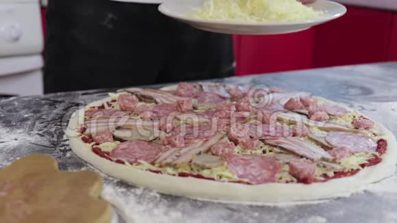 男人的手把奶酪撒在面团上用番茄酱做成披萨视频的预览图