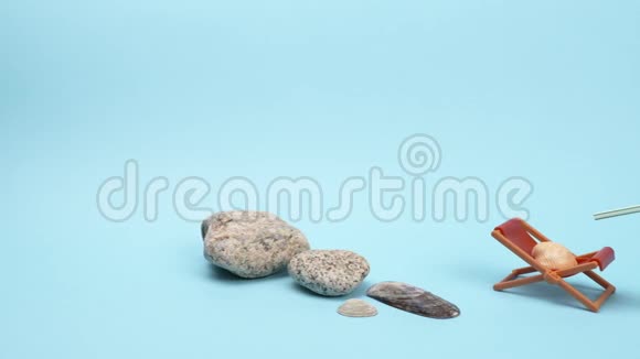 海石和贝壳一杯鸡尾酒和一个蓝色背景的太阳休息室视频的预览图