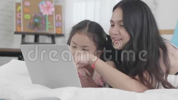 亚洲女孩和姐妹正在使用笔记本电脑电脑和平板电脑连接网络世界视频的预览图