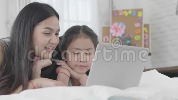 亚洲女孩和姐妹正在使用笔记本电脑电脑和平板电脑连接网络世界视频的预览图