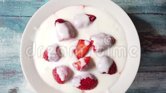 早餐在桌上的盘子里放草莓的酸奶盘子在桌子上旋转视频的预览图