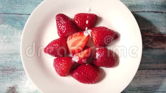 酸奶与草莓在一个盘子上的早餐把酸奶油倒在草莓上从上往下看视频的预览图
