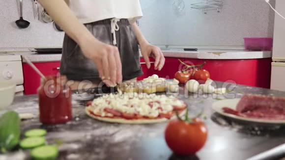 年轻女孩的手洒奶酪披萨面团视频的预览图