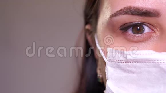 戴着医用口罩的女人女人的眼睛特写冠状病毒流行或疾病的概念视频的预览图