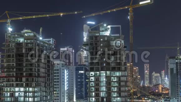 在迪拜摩天大楼正在建造中有着巨大的起重机夜间时间推移视频的预览图
