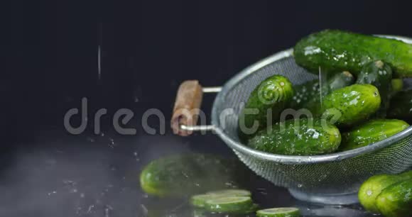 一堆新鲜黄瓜放在一个冒口里上面有水滴和冷却的蒸汽视频的预览图
