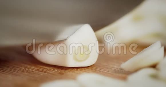 一把刀把大蒜切成小块放在木桌上视频的预览图