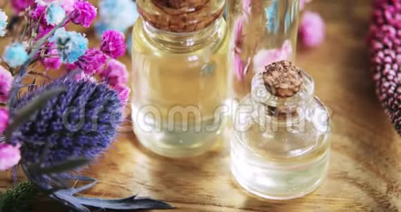 精油玻璃瓶中的香水在新鲜的花朵中戴上软木帽视频的预览图