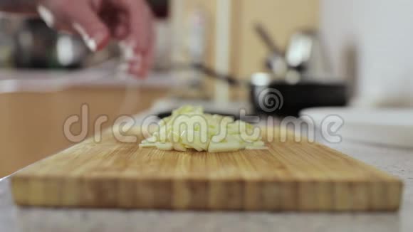 女人在木切割板上切蒜侧视特写视频的预览图