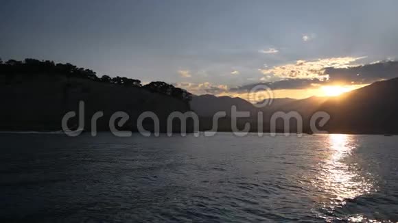 从船上看日落水的表面和云的天空的彩色景色视频的预览图
