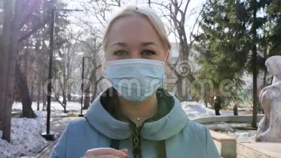 年轻的金发欧洲女人戴着医疗保护面具在城里疾病保护冠状病毒病毒性疾病视频的预览图