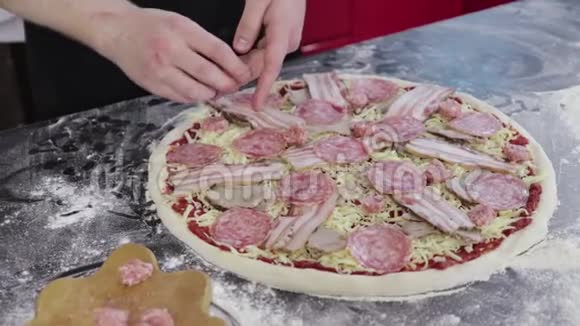 年轻人的手把香肠放在披萨面团上视频的预览图