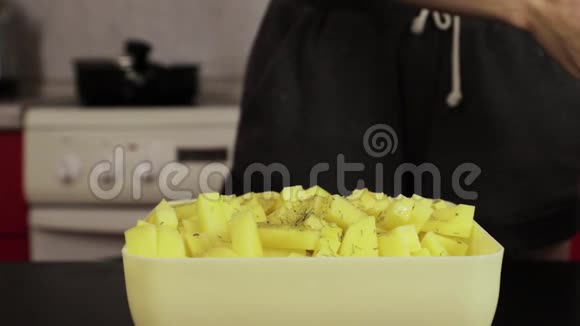 女孩在家里的厨房里撒土豆椒视频的预览图