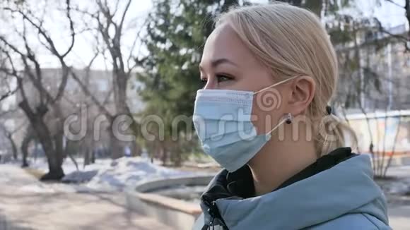 年轻的金发欧洲女人戴着医疗保护面具在城里疾病保护冠状病毒病毒性疾病视频的预览图