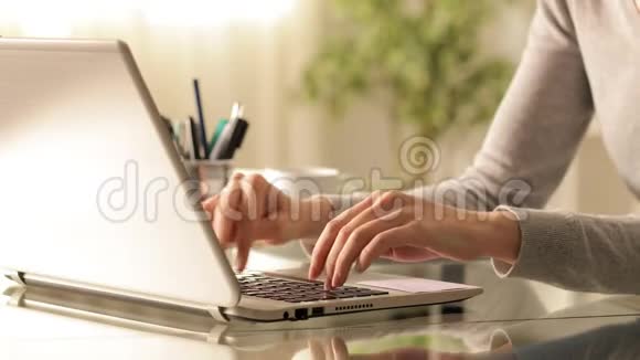 女人用手在桌上的笔记本电脑上打字视频的预览图