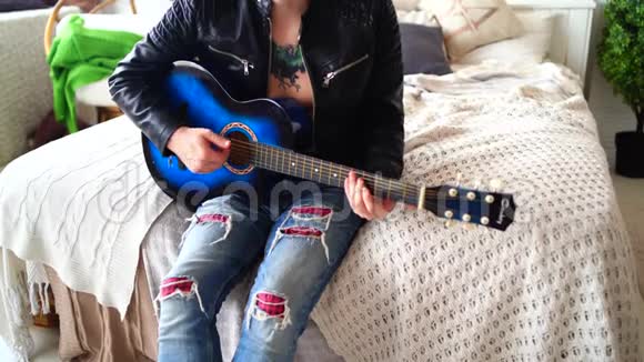 一个胸前有纹身的年轻人在卧室里弹吉他希普斯特学会弹吉他特写镜头视频的预览图
