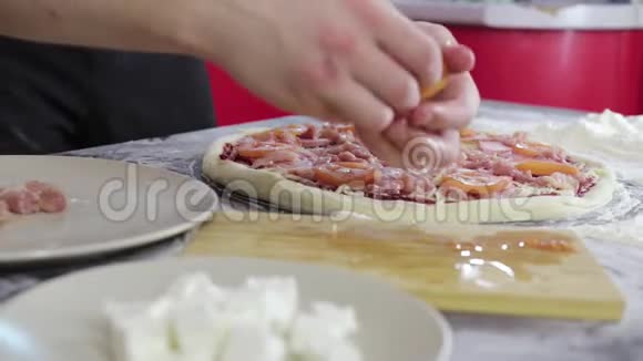 男人的手把西红柿和奶酪放在肉饼面团上视频的预览图