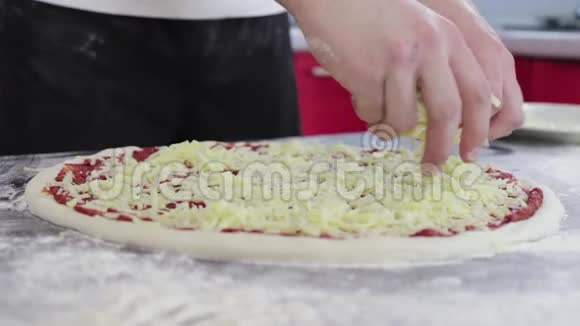 男人的手把奶酪撒在面团上用番茄酱做成披萨视频的预览图