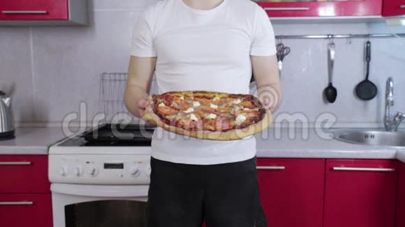 穿白色t恤的男人拿着准备好披萨视频的预览图