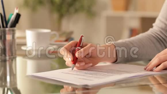 女士双手检查并在桌上签名视频的预览图