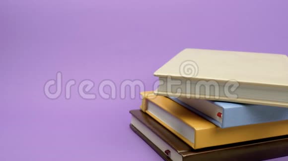 彩色日记躺在紫色的背景上视频的预览图