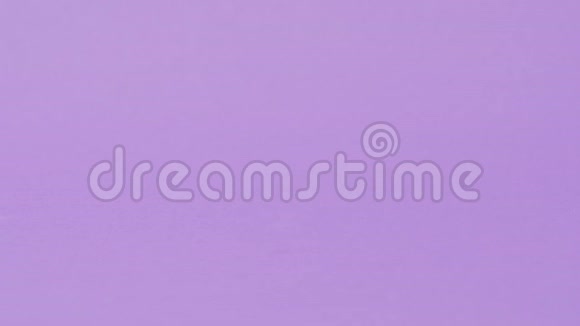 手把一块平板放在紫色的背景上视频的预览图
