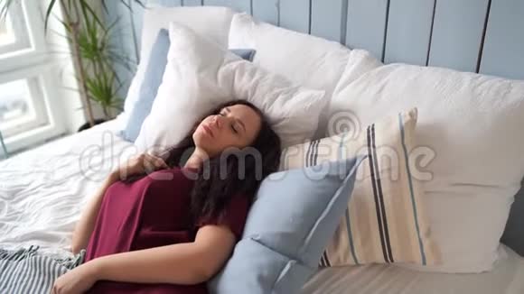 白天睡在枕头上的年轻女人穿着睡衣的成年女性因疲劳而睡着了视频的预览图