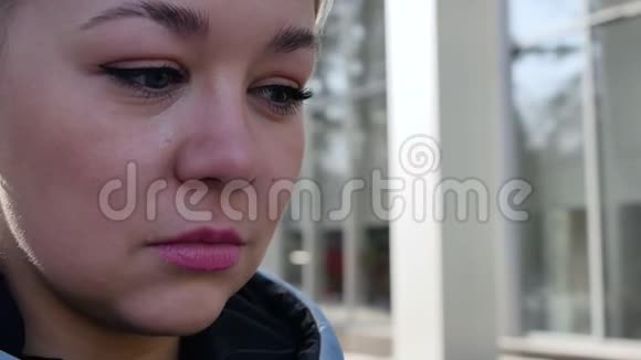 哭着的金发碧眼的肖像眼泪顺着一个年轻女人的脸滚下来一个悲伤的女人擦着她的脸眼睛里充满了视频的预览图