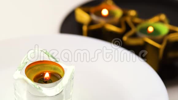 蜡烛在玻璃架上旋转在其他蜡烛的背景下模糊视频的预览图