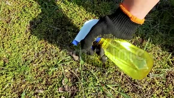 园丁用手喷黄色的瓶子视频的预览图
