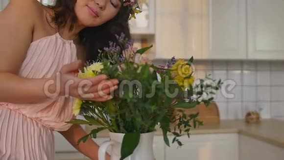 一位美丽的亚洲年轻女子头上戴着春花花环穿着一件精致的粉红色裙子视频的预览图