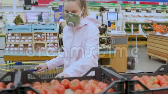 一名戴防护面罩的妇女在超市精心挑选蔬菜采取检疫冠状病毒安全措施视频的预览图