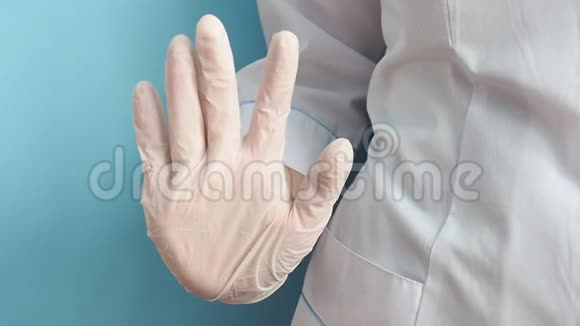 一位穿着白色实验室外套的医生用乳胶手套的手显示了一个停车标志距离视频的预览图