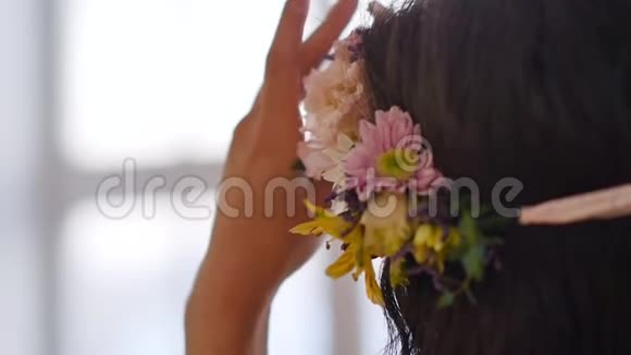 一位美丽动人的亚洲年轻女子头上戴着春花花环穿着一件精致的粉红色连衣裙视频的预览图