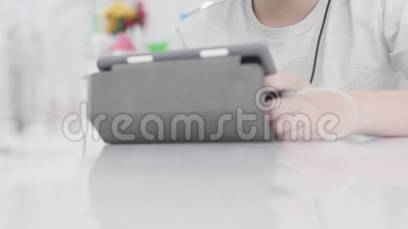 亚洲男孩用平板电脑和朋友玩网络游戏视频的预览图