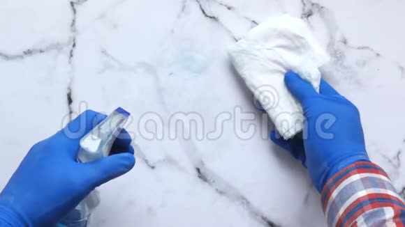 手提蓝色橡胶手套拿清洁布和喷雾瓶视频的预览图