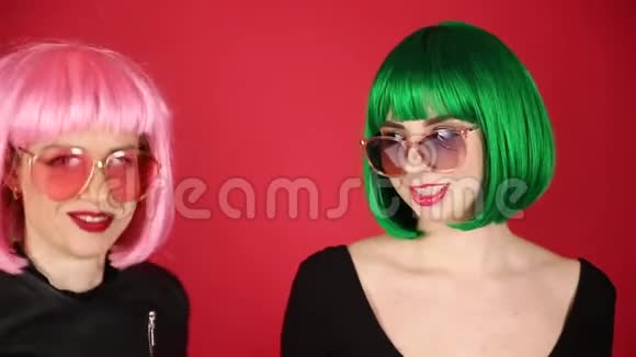 两个戴着绿色假发和太阳镜的漂亮女孩鬼脸四处闲逛表达不同的情绪视频的预览图