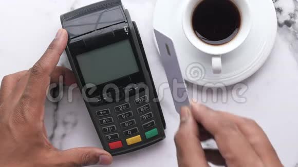 男人手里拿着一张信用卡在终端前视频的预览图