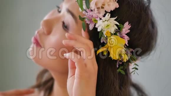 一位美丽动人的亚洲年轻女子头上戴着春花花环穿着一件精致的粉红色连衣裙视频的预览图