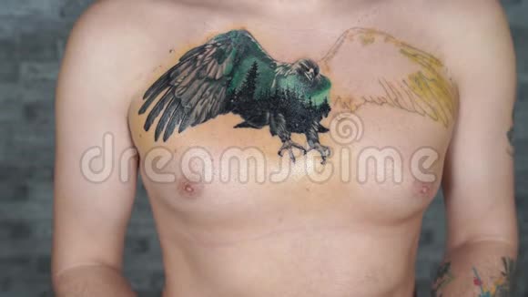 男人在胸前不完整的纹身上涂抹奶油男人的特写用手把药膏涂抹在身体的一部分视频的预览图