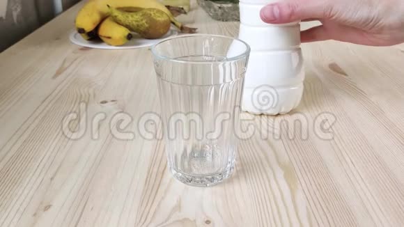 凯菲酸牛奶或白色饮用酸奶从瓶子倒入刻面玻璃发酵乳制品浓饮料视频的预览图
