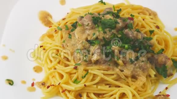 肉和奶油酱的意大利面洒上新鲜的草药视频的预览图