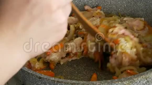 烤洋葱胡萝卜在煎锅里切碎用木抹子搅拌视频的预览图