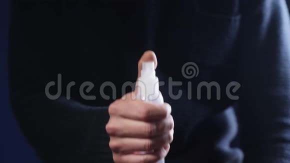 一个男人拿着瓶子喷洒消毒剂视频的预览图