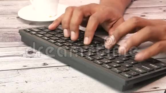 手指在木桌上的键盘上打字关闭视频的预览图