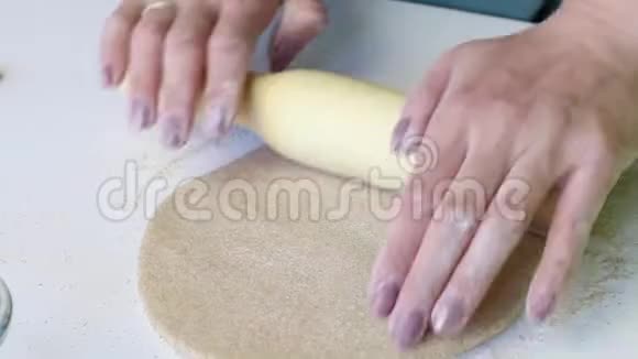 一个女人小心翼翼地用擀面杖卷一块面团准备一个新的玉米饼特写视频的预览图
