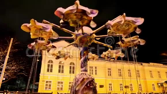 旋转木马在夜城的背景下从一阵强风中旋转视频的预览图