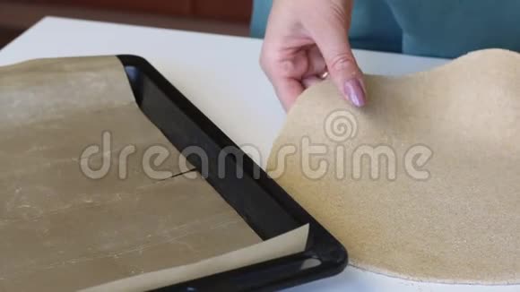 一个女人把一个圆面团蛋糕放在烤盘上上面有一个硅胶垫准备一个新的玉米饼视频的预览图